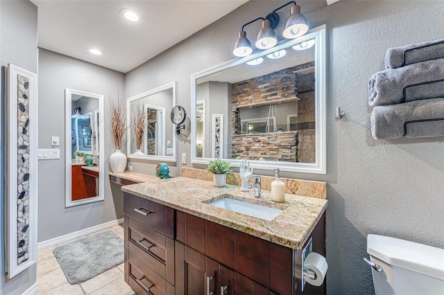 bathroom featuring toilet, tile patterned flooring, and vanity