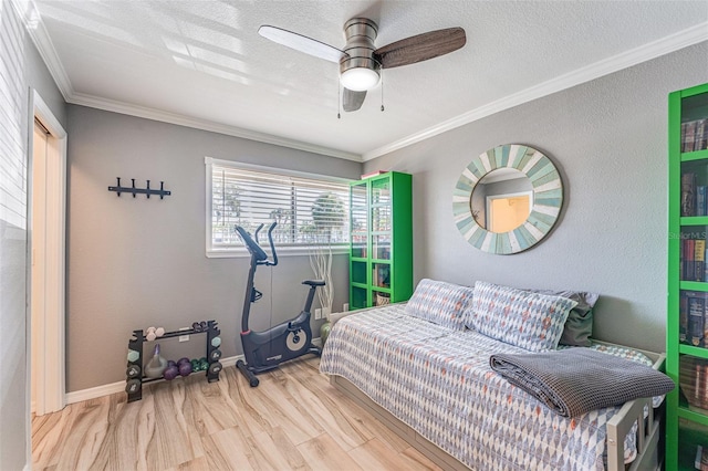 bedroom featuring ceiling fan, light wood-type flooring, crown molding, and a textured ceiling