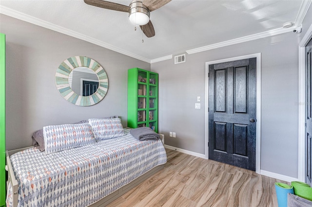 bedroom with ornamental molding, ceiling fan, and light hardwood / wood-style flooring