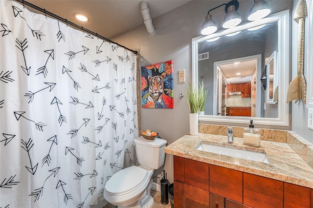 bathroom featuring toilet, a shower with shower curtain, and vanity