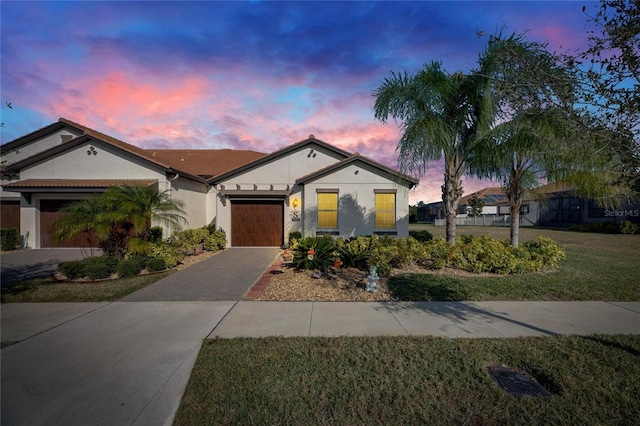 view of front of home with a yard and a garage