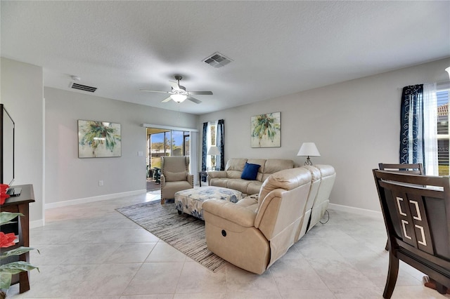 tiled living room with a healthy amount of sunlight, ceiling fan, and a textured ceiling