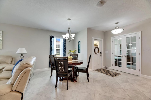 dining room featuring french doors, a textured ceiling, a chandelier, and light tile patterned floors