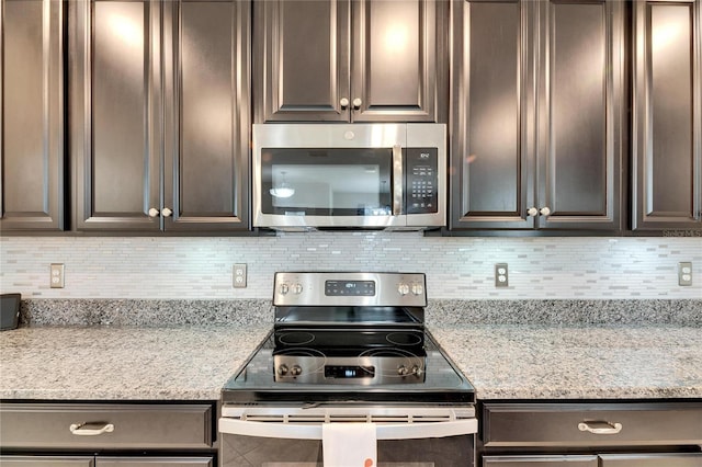 kitchen featuring light stone countertops, appliances with stainless steel finishes, and tasteful backsplash