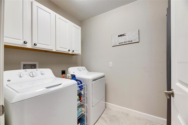 laundry room featuring cabinets, washing machine and dryer, and light tile patterned flooring