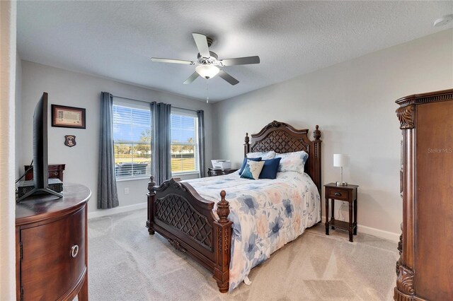 carpeted bedroom featuring a textured ceiling and ceiling fan