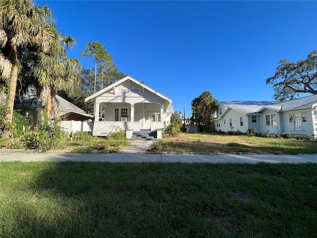 bungalow with a front yard and covered porch