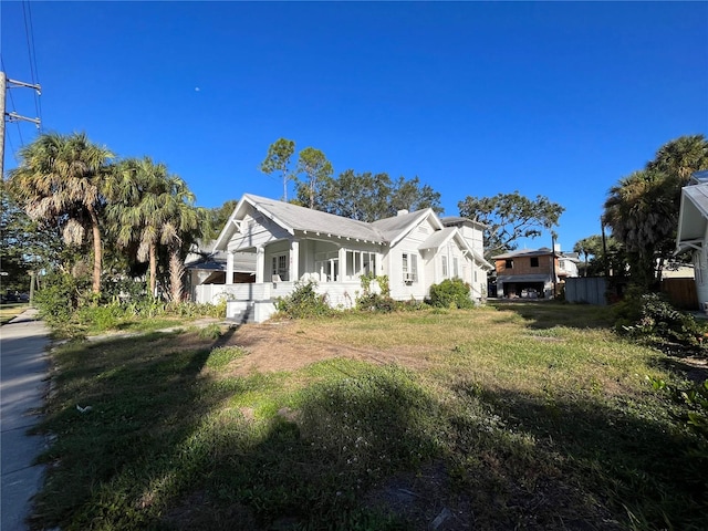 view of side of property featuring a yard and covered porch