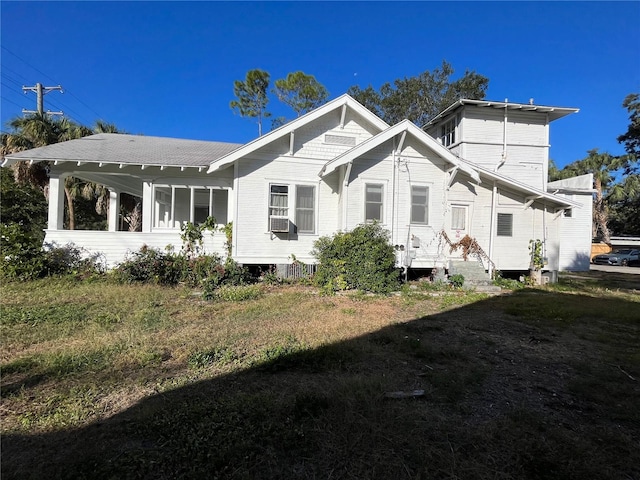 back of property featuring cooling unit and a lawn