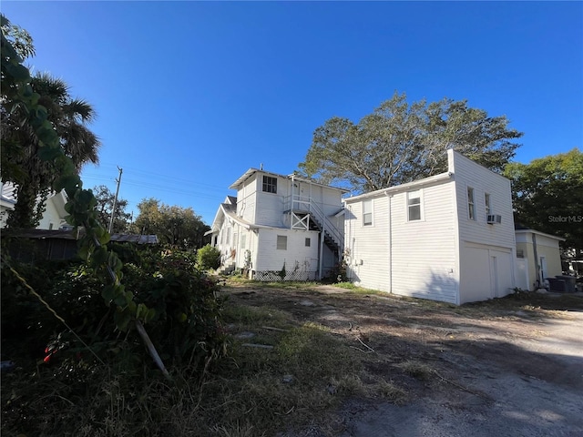 exterior space with a garage, cooling unit, and central AC unit