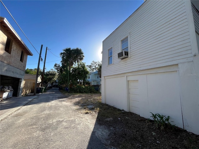 view of side of home with a garage and cooling unit