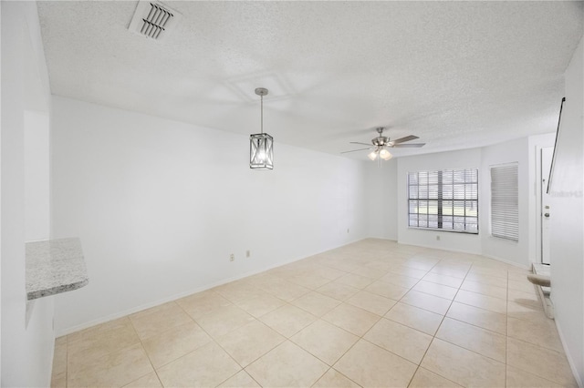 tiled spare room featuring ceiling fan and a textured ceiling