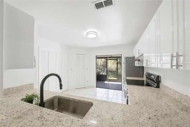 kitchen with light stone countertops, sink, white cabinets, and stainless steel electric range oven