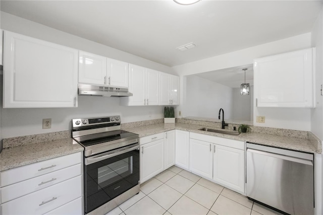 kitchen featuring hanging light fixtures, sink, white cabinets, stainless steel appliances, and light tile patterned flooring