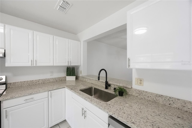 kitchen featuring light stone countertops, sink, and white cabinetry