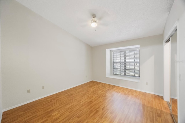 empty room with ceiling fan, hardwood / wood-style floors, and a textured ceiling