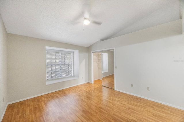 empty room featuring ceiling fan, light hardwood / wood-style floors, and lofted ceiling