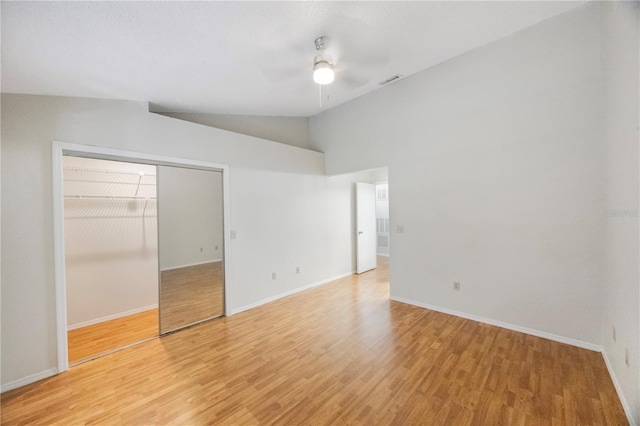 unfurnished bedroom featuring a closet, ceiling fan, hardwood / wood-style floors, and lofted ceiling