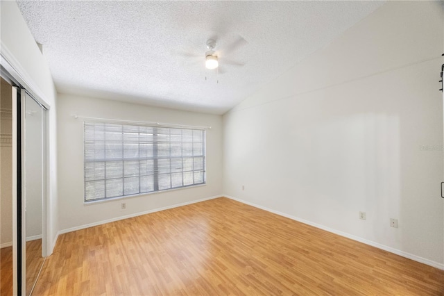 unfurnished bedroom with light hardwood / wood-style floors, a textured ceiling, a closet, and ceiling fan