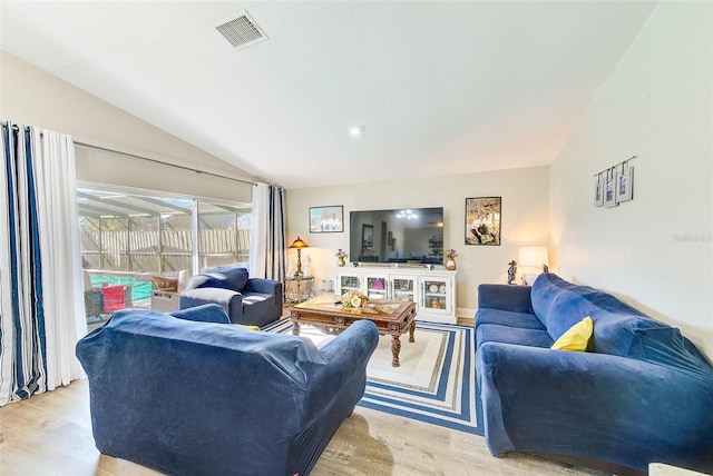 living room with vaulted ceiling and light wood-type flooring