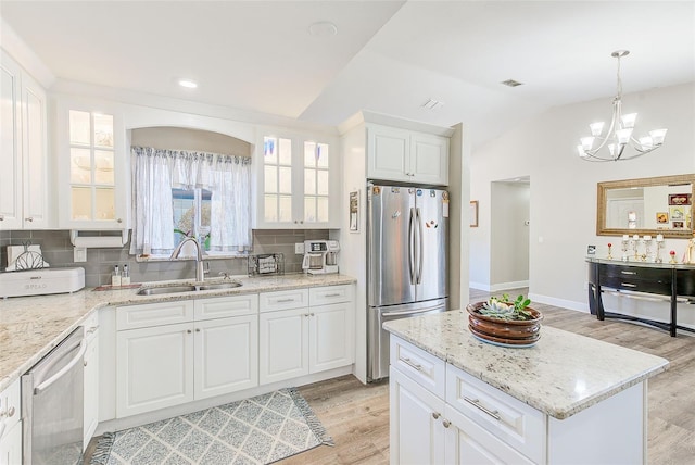 kitchen with white cabinetry, stainless steel appliances, sink, and decorative backsplash