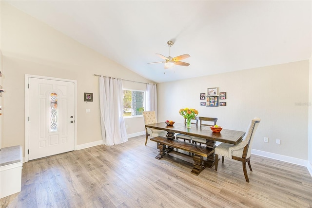 dining area with ceiling fan, vaulted ceiling, and light wood-type flooring