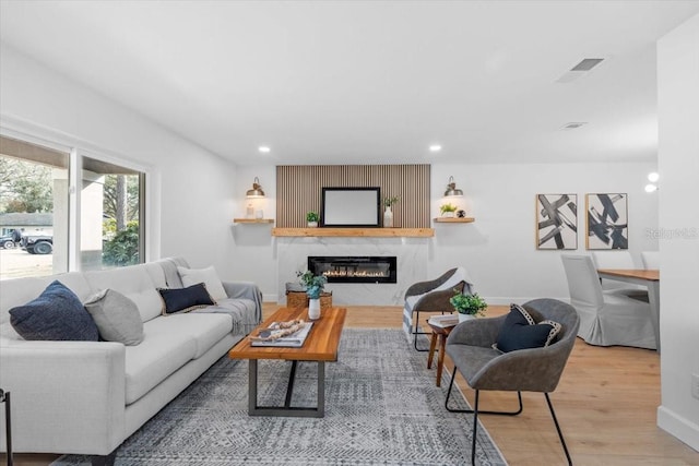 living room featuring a high end fireplace and wood-type flooring