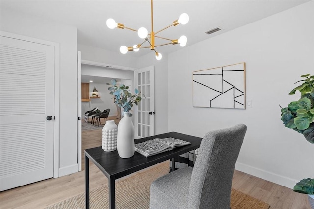 office space with light wood-type flooring, french doors, and a chandelier