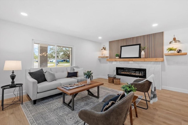 living room featuring a high end fireplace and hardwood / wood-style floors