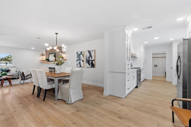 dining space featuring a notable chandelier and light hardwood / wood-style flooring