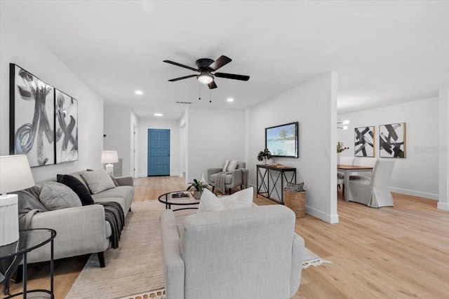 living room featuring ceiling fan and light hardwood / wood-style floors