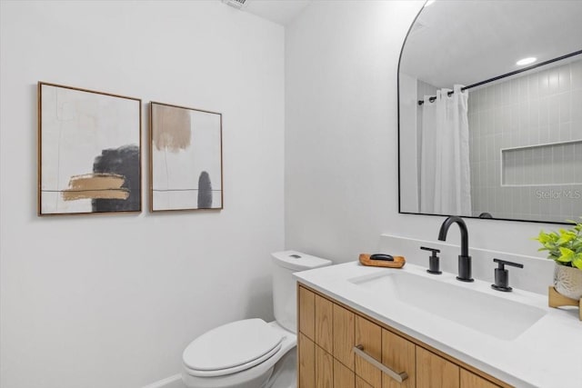 bathroom with toilet, walk in shower, and vanity