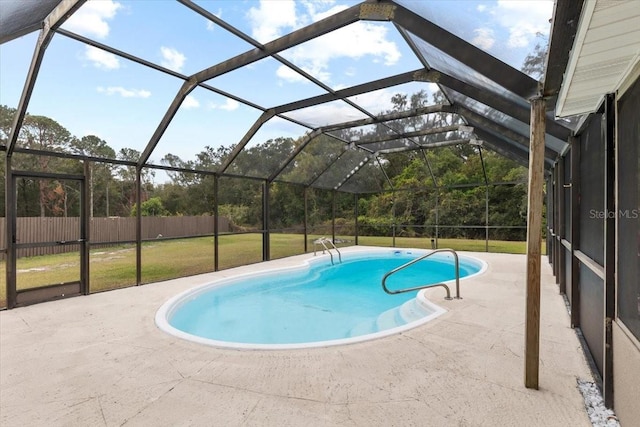 view of swimming pool featuring a lanai, a lawn, and a patio area