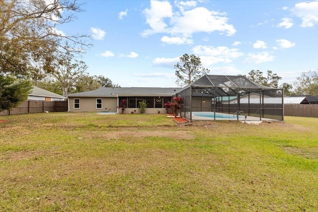 back of property featuring a fenced in pool, a yard, a sunroom, and glass enclosure