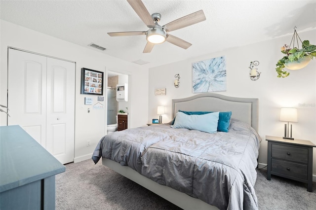 bedroom with ensuite bathroom, light colored carpet, ceiling fan, a textured ceiling, and a closet