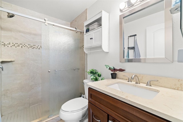 bathroom featuring vanity, toilet, and a shower with door