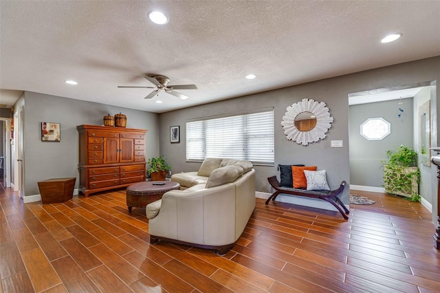 living room with a textured ceiling and ceiling fan