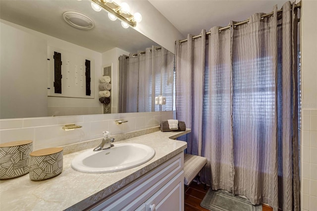 bathroom featuring tile walls, vanity, tasteful backsplash, and curtained shower