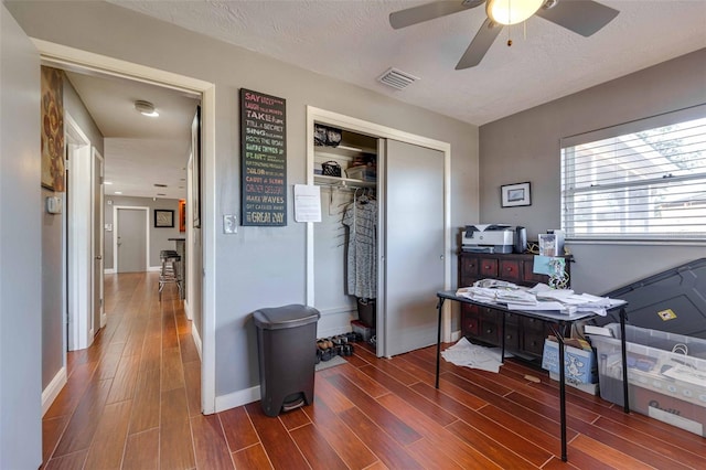 office space with a textured ceiling, ceiling fan, and dark hardwood / wood-style floors