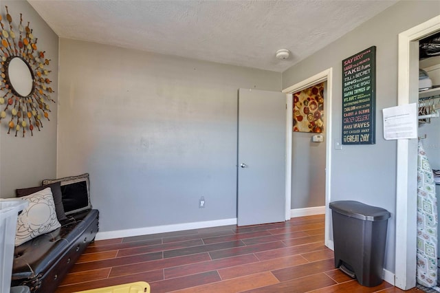 sitting room with a textured ceiling and dark hardwood / wood-style flooring