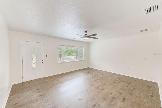 entrance foyer with light hardwood / wood-style floors, a textured ceiling, and ceiling fan