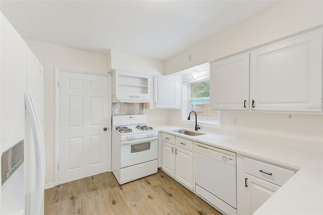 kitchen with sink, white appliances, white cabinets, and light hardwood / wood-style flooring