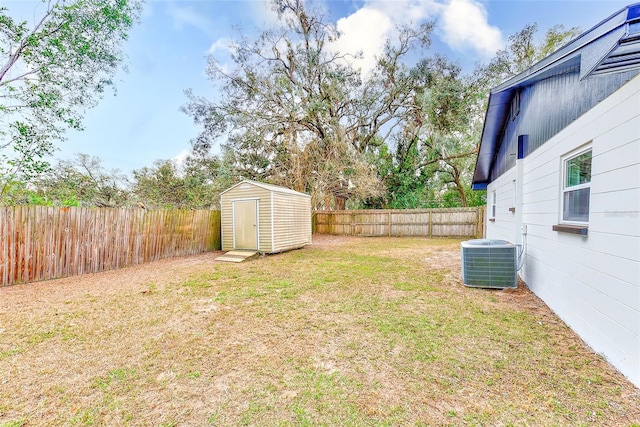 view of yard with central AC unit and a storage shed