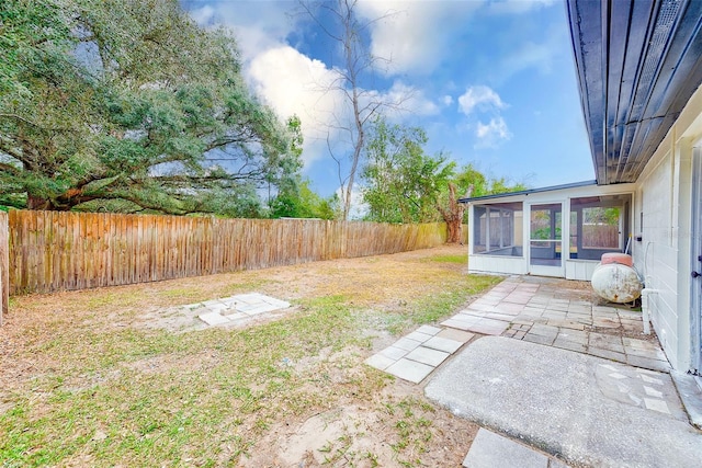 view of yard featuring a sunroom and a patio