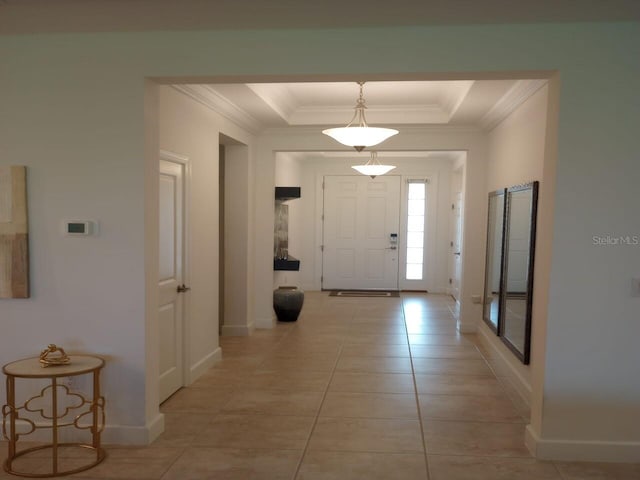 entrance foyer with light tile patterned floors and a tray ceiling