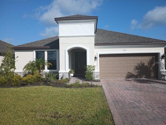 621 San Augusto Dr, Poinciana, FL 34759 - view of front of property featuring a shingled roof, decorative driveway, stone siding, a front yard, and an attached garage