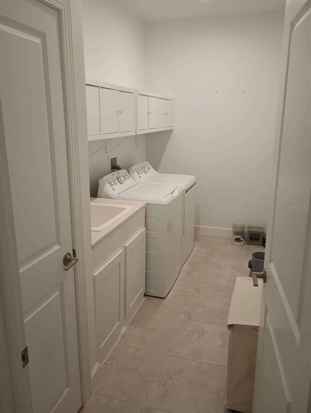 621 San Augusto Dr, Poinciana, FL 34759 - laundry room featuring light tile patterned flooring, baseboards, cabinet space, and washing machine and dryer