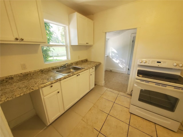 kitchen featuring electric range, light tile patterned floors, light stone counters, white cabinets, and sink