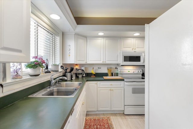 kitchen with sink, white appliances, tasteful backsplash, and white cabinets