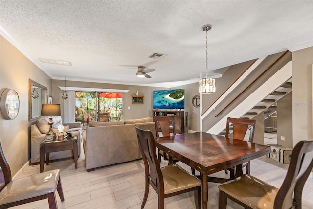 dining room with ceiling fan with notable chandelier, a textured ceiling, and ornamental molding